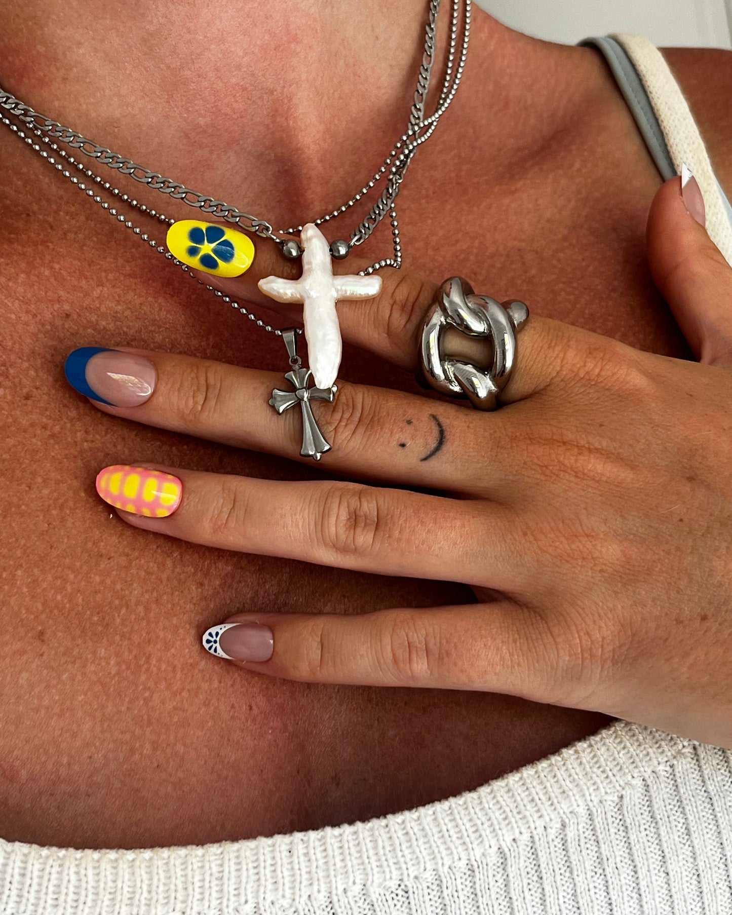 Closeup of THE PEARL CROSS NECKLACE showing freshwater pearl cross pendant and stainless steel chain, polished unisex jewelry