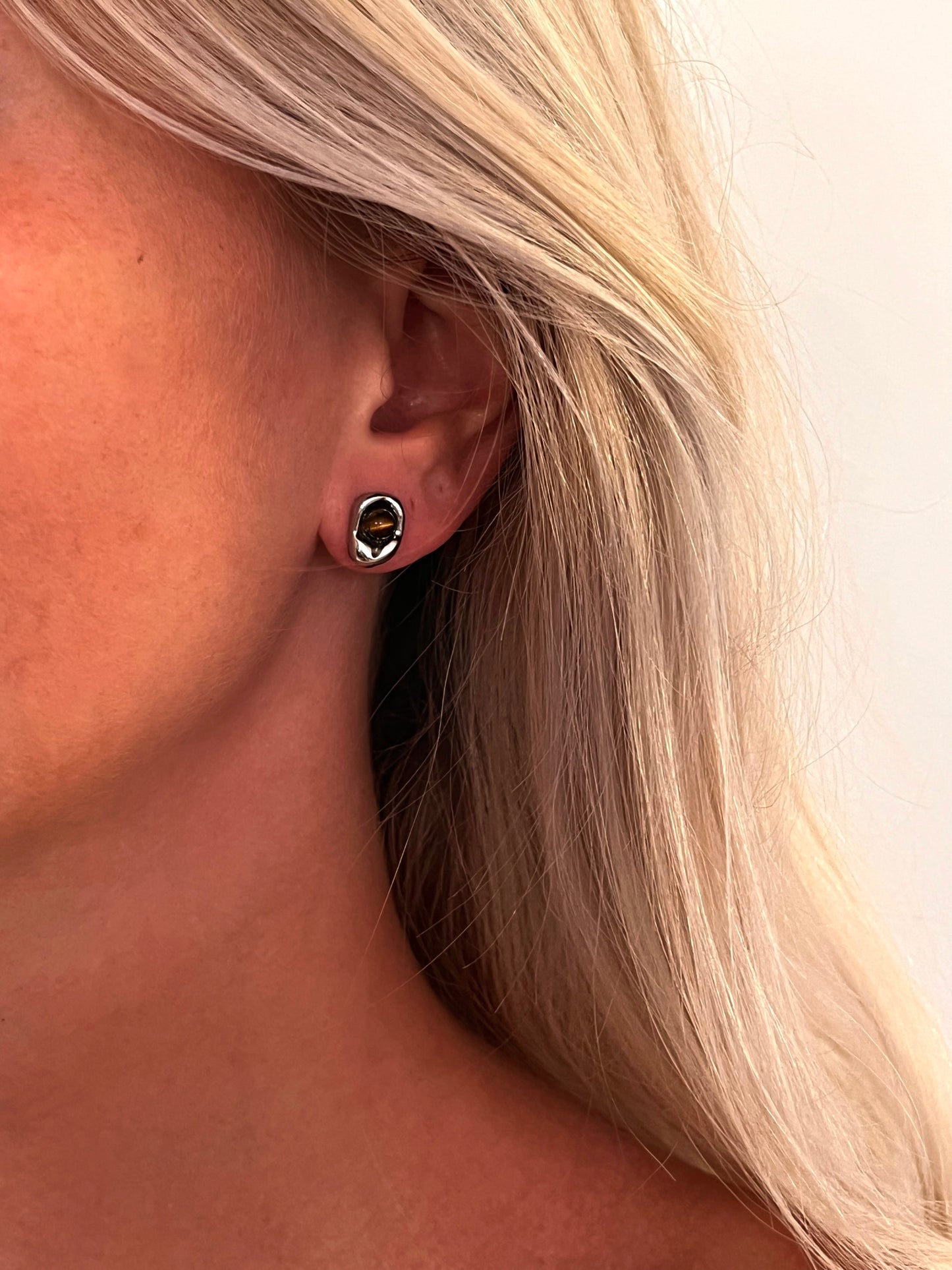 Close-up of the Auris tiger's eye stud earrings set in polished stainless steel.