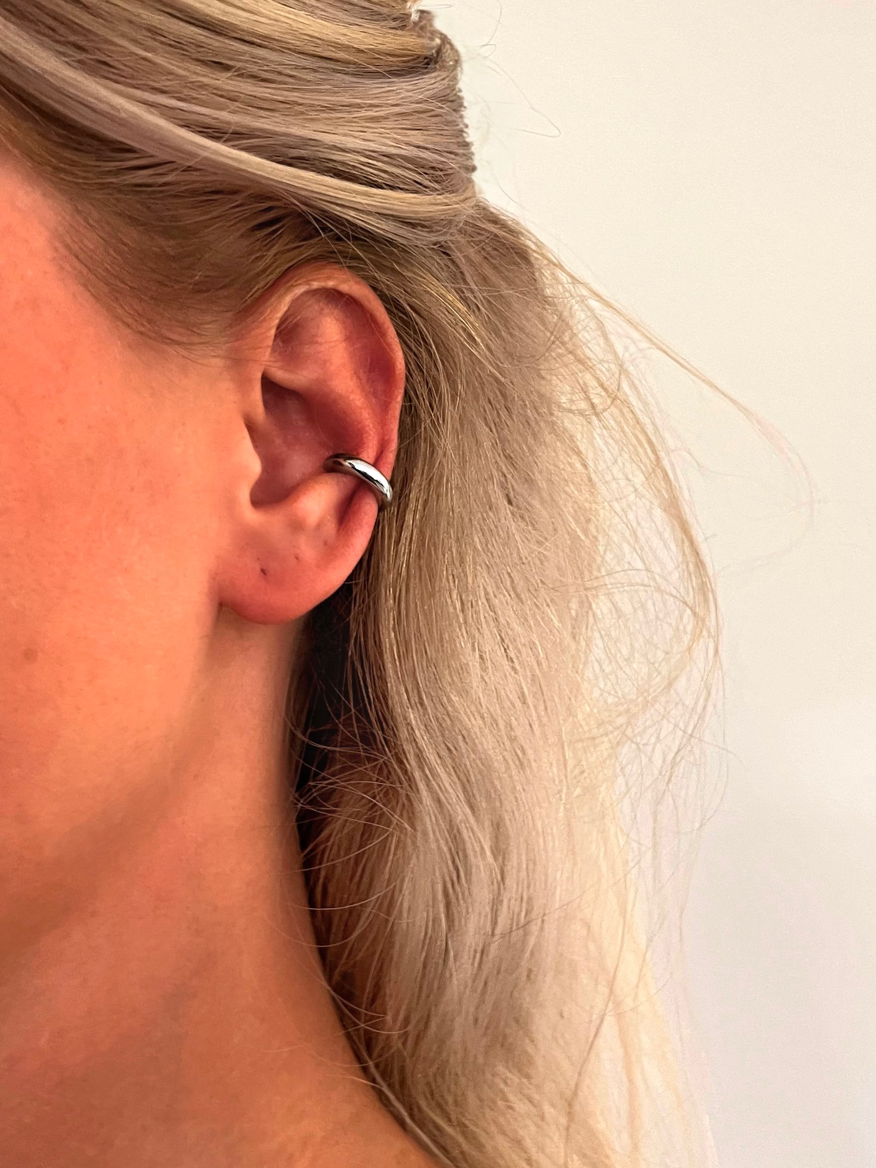 Close-up of the Forma polished stainless steel minimalist ear cuff with a clean modern design.