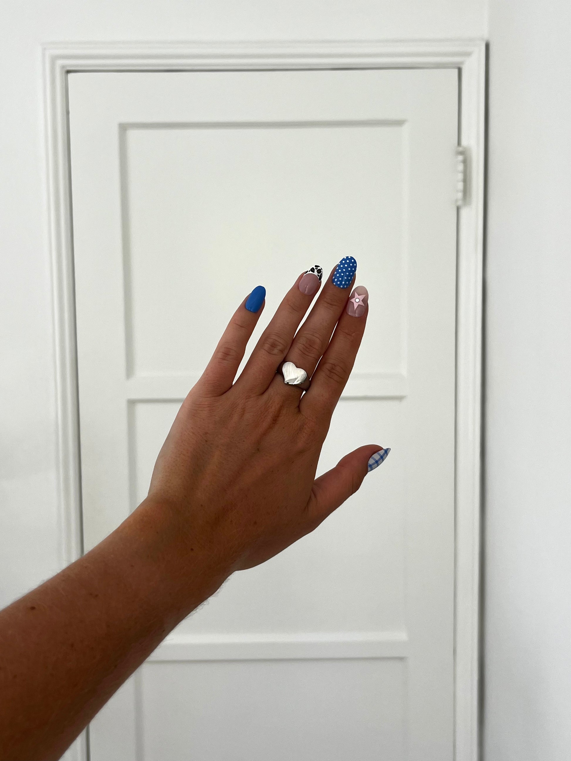 LOVIE bold heart-shaped silver ring worn on pinky, unisex statement piece for men and women.