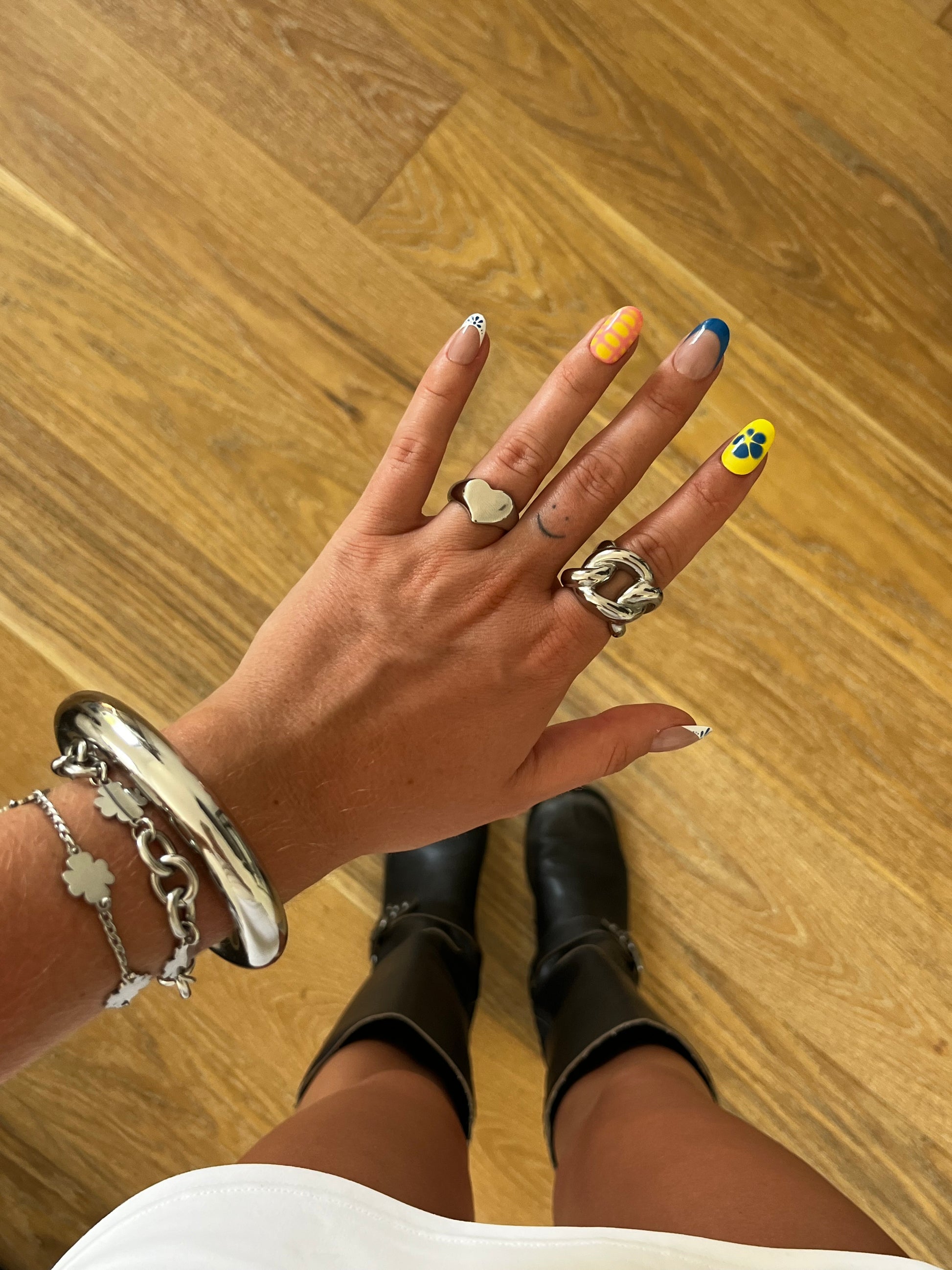 Model wearing LOVIE heart-shaped silver ring on finger, playful yet timeless unisex jewelry.