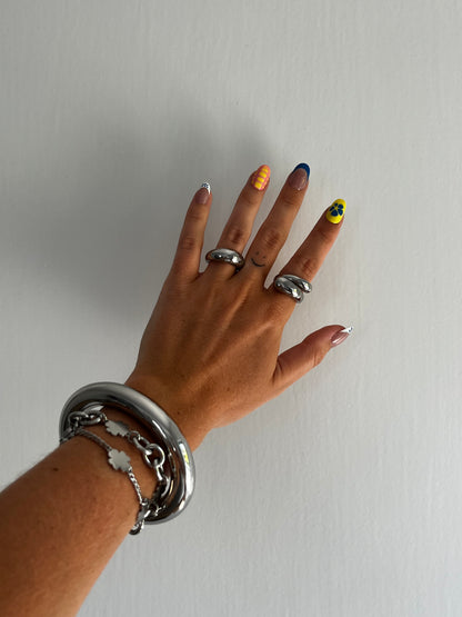 unisex statement silver stainless steel small dome ring paired with spin dome ring, high polished bangle, and four leaf pendant chain bracelet set