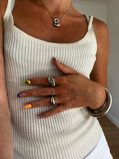 model wearing unisex silver stainless steel spin wrap around dome ring, statement jewelry for men and women