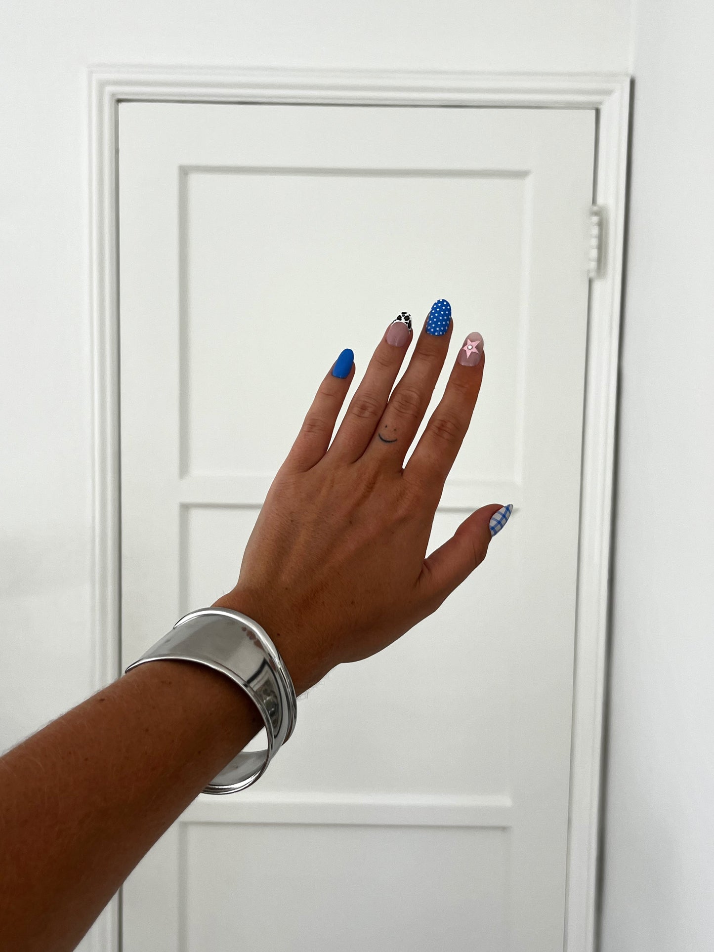 Sideview of THE ABBIE BANGLE highlighting fluid curves and polished stainless steel, unisex statement piece