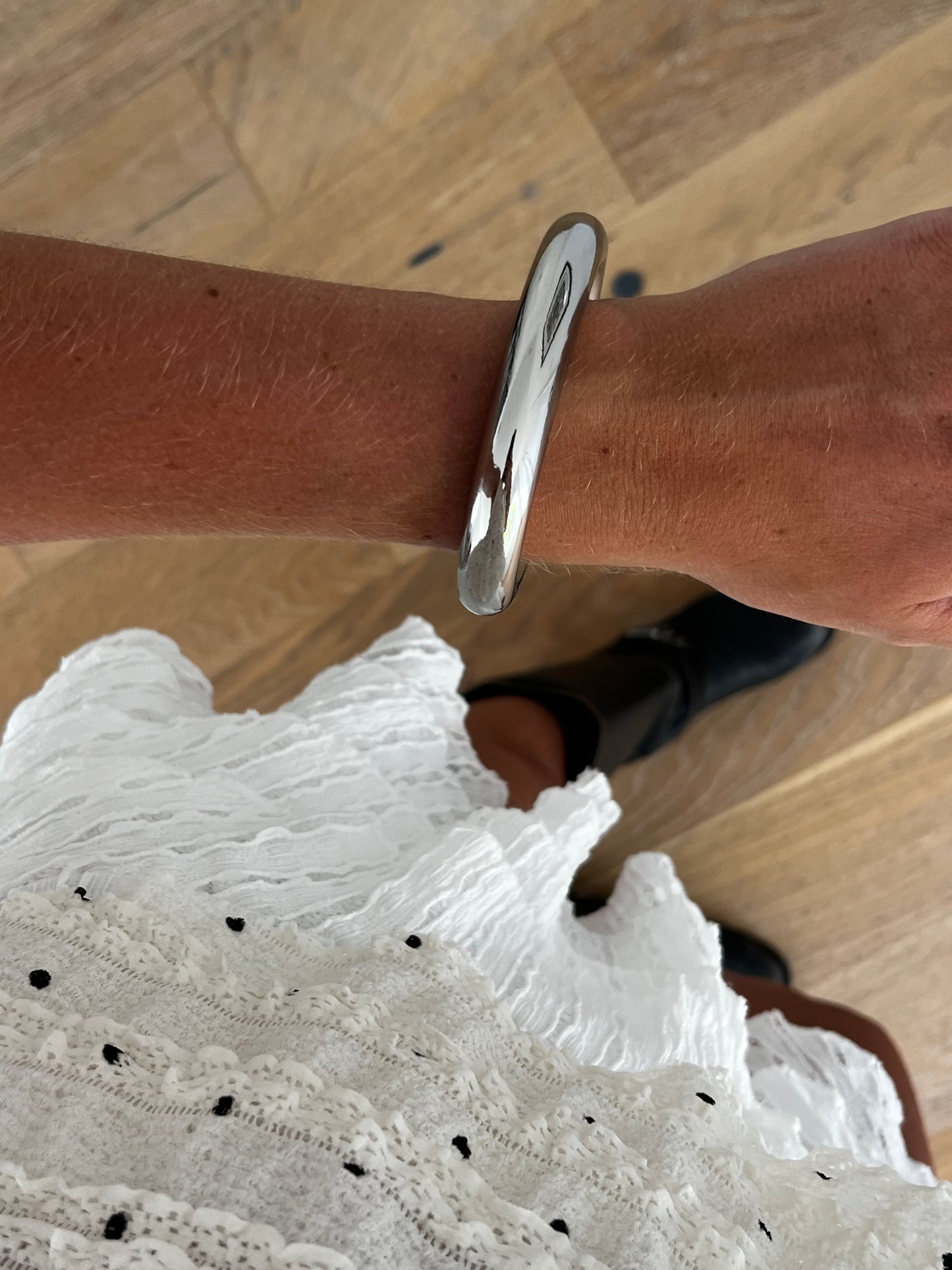 Closeup of THE CLEAN BANGLE highlighting smooth high-polish surface, stainless steel unisex bracelet