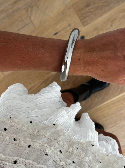 Closeup of THE CLEAN BANGLE highlighting smooth high-polish surface, stainless steel unisex bracelet
