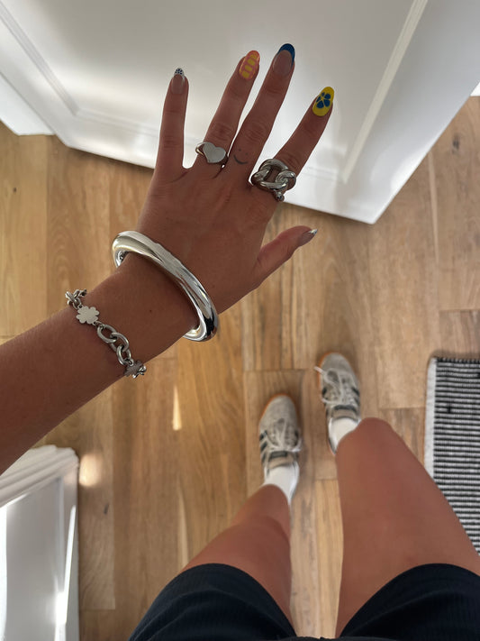 Model wearing THE CLEAN BANGLE high-polish stainless steel bracelet, effortless unisex jewelry.