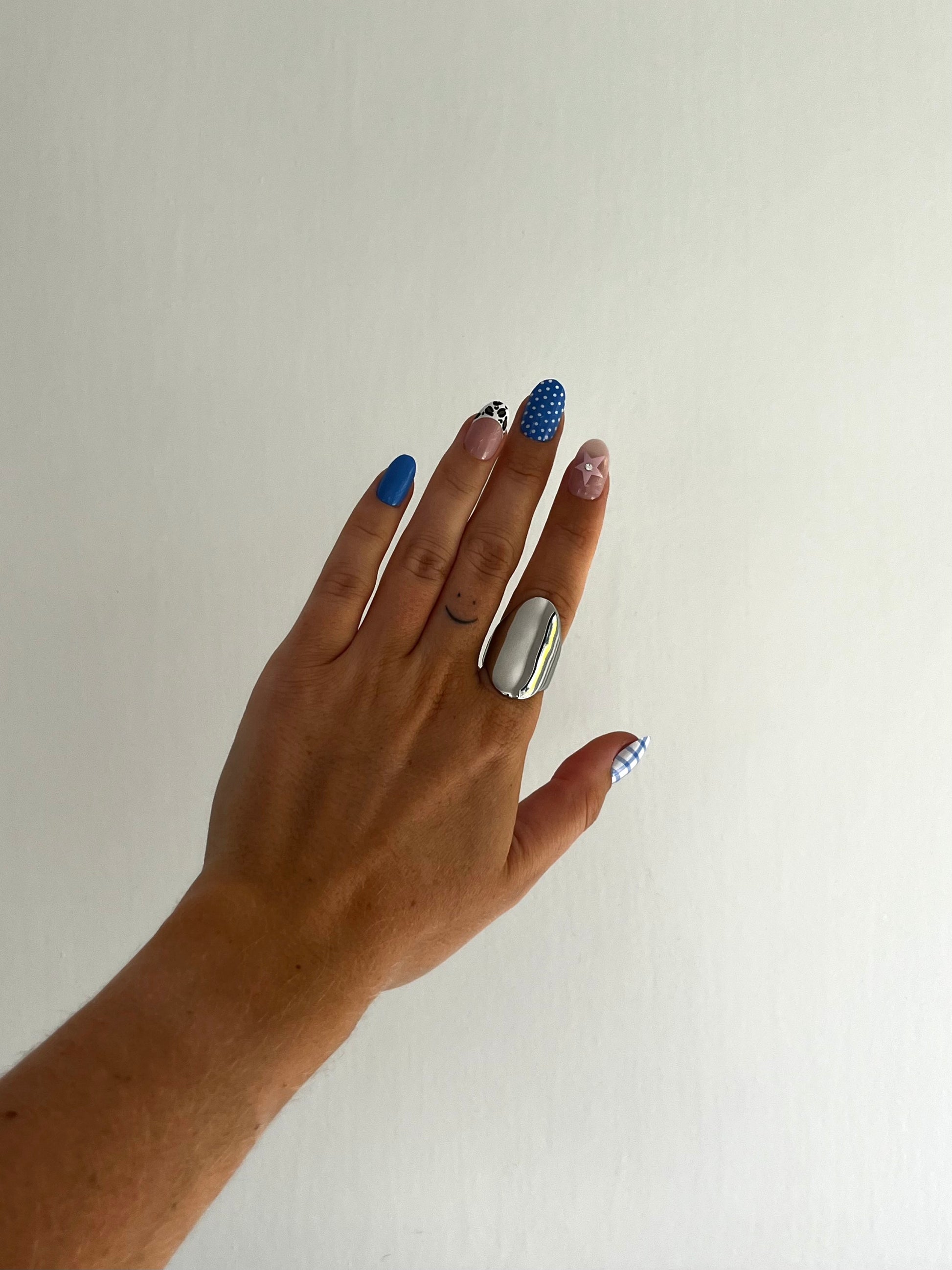 Angled view of THE OVA stainless steel sculptural ring, unisex statement piece with fluid design