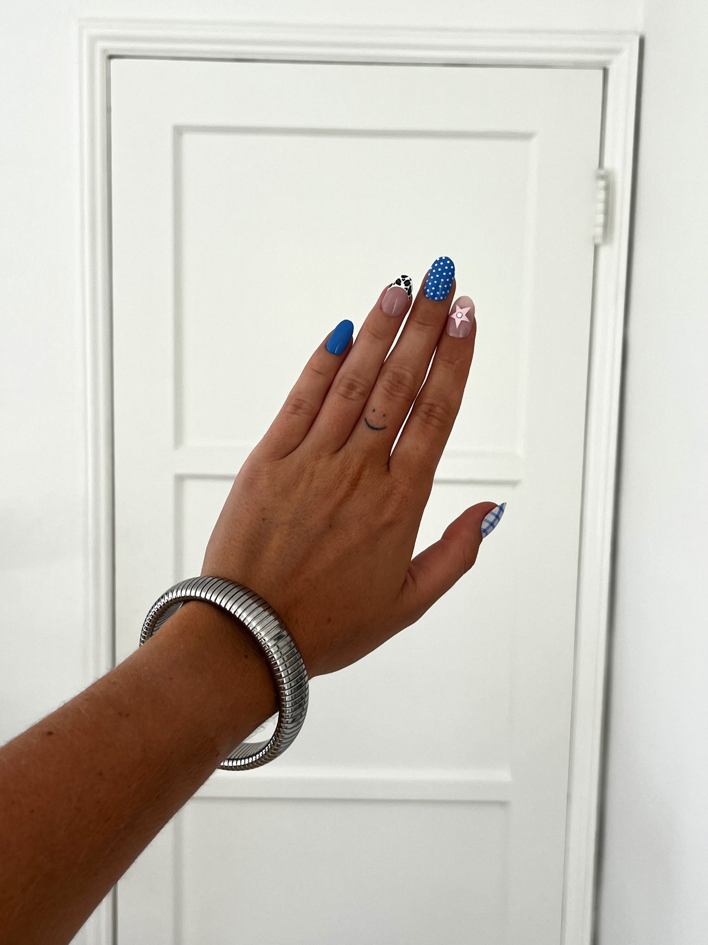 THE SPRING BANGLE, coiled high-polish stainless steel bracelet with flexible silhouette, unisex statement jewelry