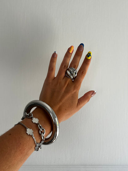 Closeup of THE WHORL stainless steel silver ring showing fluid twisted design, heavy and bold unisex statement piece.